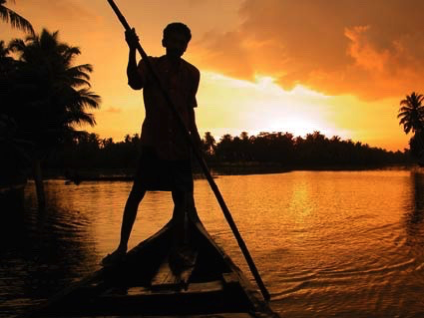 boy fishing on boat in sunset