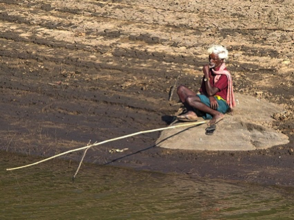 white haired old man contemplating with fishing rod